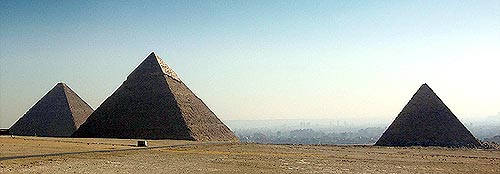 Tři egyptské pyramidy v poušti nad městem